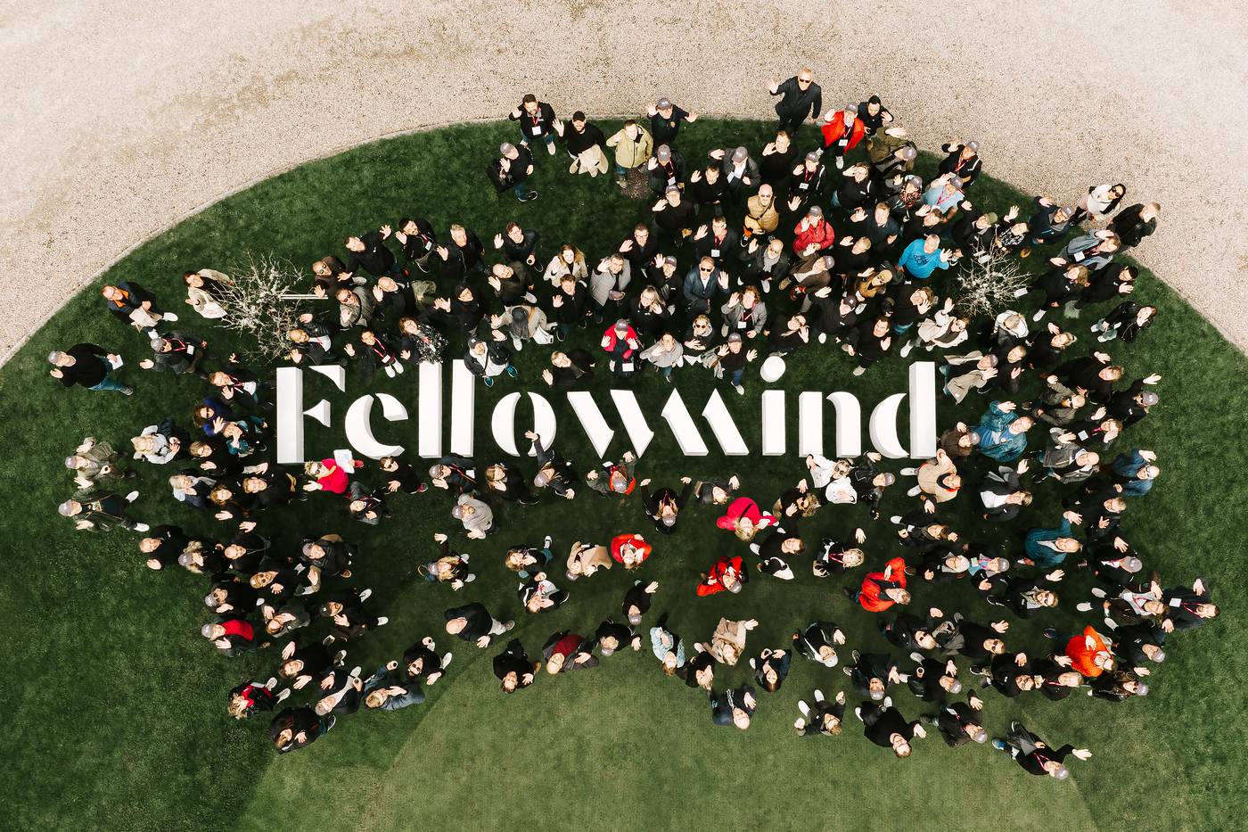 Aerial photo of Fellowmind employees gathered around a giant Fellowmind sign