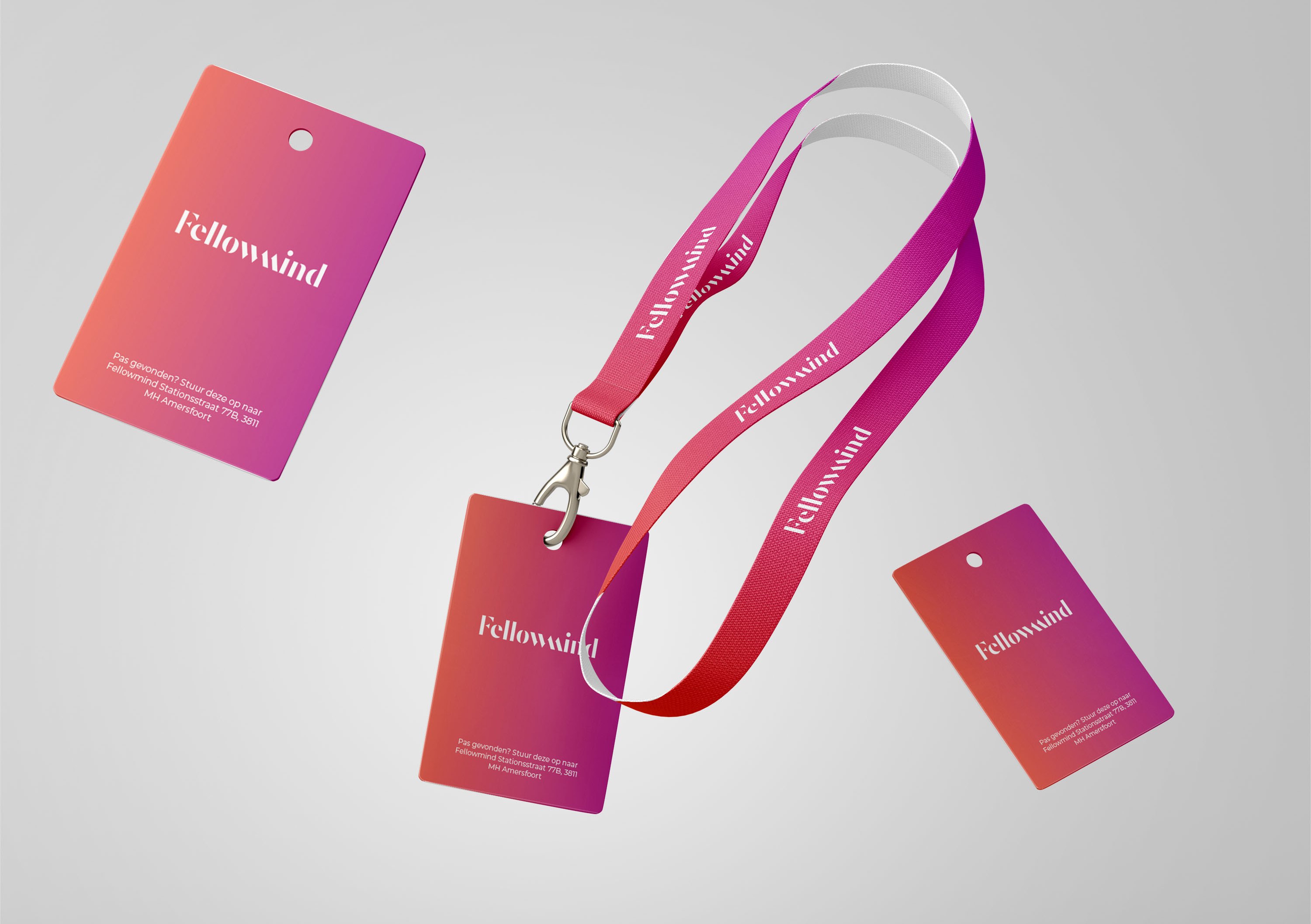 Fellowmind event lanyard and badge cards in the orange to magenta brand gradient with the serif wordmark